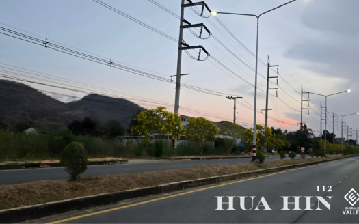 Scenic mountain view along the Hua Hin 112 road near Emerald Valley Hua Hin featuring vibrant yellow flowering trees at sunset.